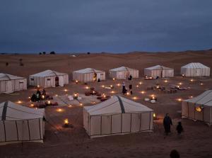 eine Gruppe von Zelten in der Wüste in der Nacht in der Unterkunft Dar diafa samira in Mirleft