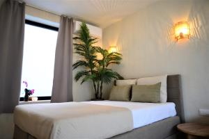 a bedroom with a large bed with a plant on it at Kyoto Suites - Center Antwerp! in Antwerp