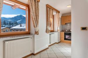 a kitchen with a large window with a mountain view at Cima Dodici A Parte in Soraga