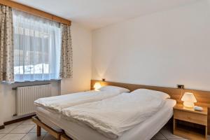 a bedroom with two beds and a window at Cima Dodici A Parte in Soraga