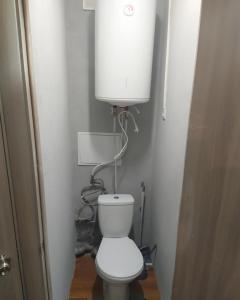 a small bathroom with a toilet with a water tank at 3-х комнатная квартира по улице Коцюбинского, дом 9 дробь 6 in Kremenchuk