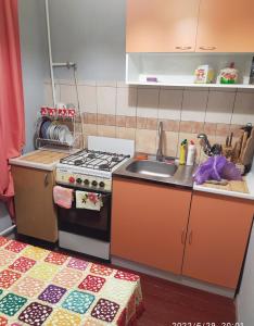 a small kitchen with a stove and a sink at 3-х комнатная квартира по улице Коцюбинского, дом 9 дробь 6 in Kremenchuk