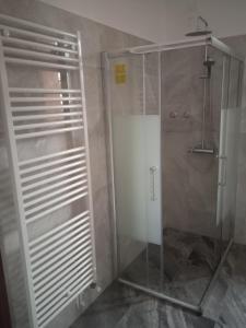 La salle de bains est pourvue d'une douche avec une porte en verre. dans l'établissement Ca' Giorgio, à Cavallino-Treporti