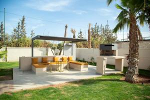 een patio met een tafel en stoelen onder een luifel bij Magnifique nouvelle Villa avec Piscine chauffée in Marrakesh