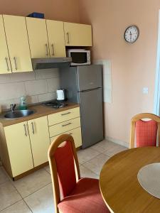 a small kitchen with a table and a refrigerator at Apartments Pralija in Sevid