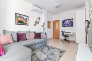 ein Wohnzimmer mit einem Sofa und einem Schreibtisch in der Unterkunft Home2Book El Perenquén Las Canteras in Las Palmas de Gran Canaria
