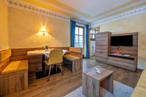 sala de estar con mesa y TV en Haus zur Vogelweide App 2, en Dobbiaco