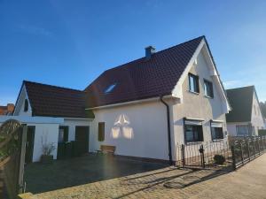 uma casa branca com um telhado preto em Anker Perla em Grömitz