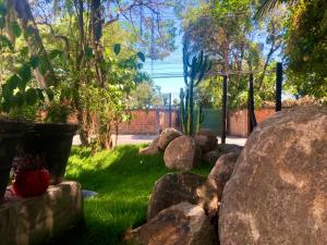 a garden with rocks in the grass and a fence at Recanto Canajurê in Florianópolis