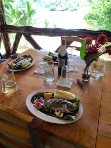 a table with a plate of food and a bottle of wine at Playa Tortuga in Puerto Misahuallí