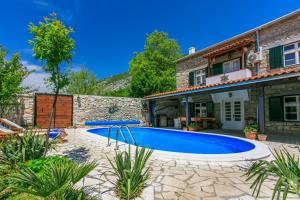 a swimming pool in the backyard of a house at Santa Barbara in Drivenik