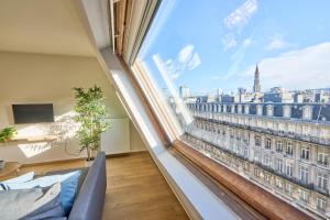 Pokój z dużym oknem z widokiem na miasto w obiekcie Downtown Brussels Apartment w Brukseli