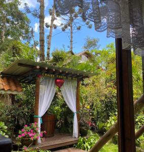 un cenador con un letrero que lee singapore gardenia en Pousada Chalés Canto do Rio, en Visconde De Maua