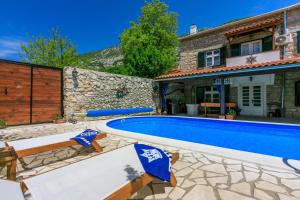 a villa with a swimming pool and a house at Santa Barbara in Drivenik