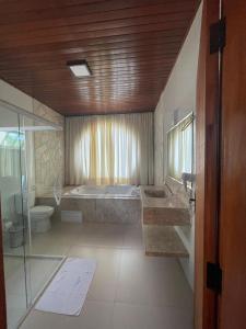 a bathroom with a tub and a sink and a toilet at Cachoeira Paraiso in Pirenópolis