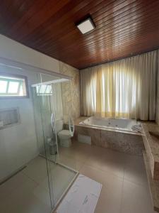 a bathroom with a tub and a shower and a toilet at Cachoeira Paraiso in Pirenópolis
