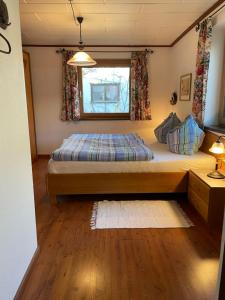 ein kleines Schlafzimmer mit einem Bett und einem Fenster in der Unterkunft Haus Wittig in Sankt Ulrich am Pillersee
