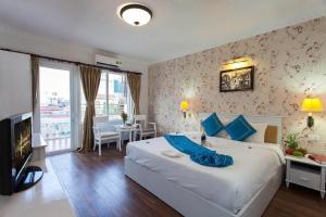una camera d'albergo con un grande letto e una TV di Hanoi Jade Hostel a Hanoi