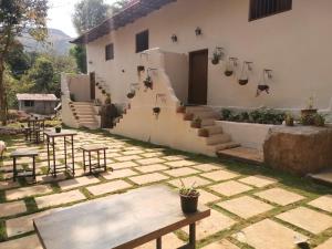 a patio with stairs and tables and a building at Achalaa Resort in Kolhapur