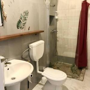 een badkamer met een toilet, een wastafel en een douche bij Bright Apartment Close to the Beach & City Center in Praia