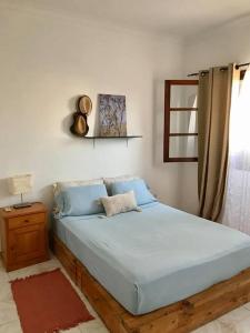 a bedroom with a large bed with blue pillows at Bright Apartment Close to the Beach & City Center in Praia
