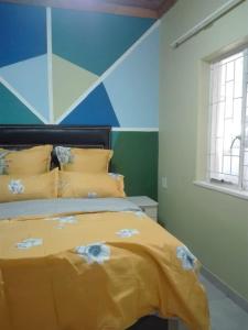a bedroom with a yellow bed with a blue wall at ALEXIA LODGE & SPA in Cape Town