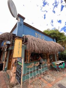 um restaurante com cadeiras e uma placa em frente em Yolo Hostel Medellin em Medellín