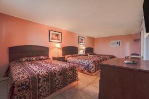 a hotel room with two beds and a desk at Monterrey Motel Padre Island, Corpus Christi BY OYO in Corpus Christi