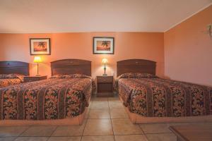 una camera d'albergo con due letti e due lampade di Monterrey Motel Padre Island, Corpus Christi BY OYO a Corpus Christi