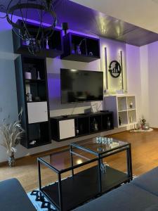 een woonkamer met een glazen tafel en een televisie bij RUBIKON self check in in Osijek