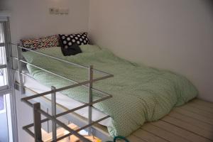 Una cama con una manta verde encima. en Tel Hai City Studio Center Apartment By Nimizz, en Tel Aviv