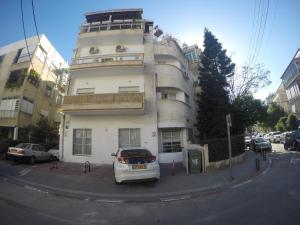 un coche blanco estacionado frente a un edificio en Tel Hai City Studio Center Apartment By Nimizz, en Tel Aviv