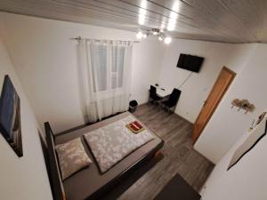 nad głową sypialni z łóżkiem i biurkiem w obiekcie HostelHollabrunn w mieście Hollabrunn +9 zdjęć