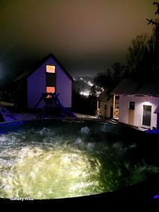 una gran piscina frente a una casa por la noche en Chatki wisla houses, en Wisła