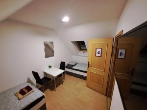 Mały pokój z łóżkiem, biurkiem i drzwiami w obiekcie HostelHollabrunn w mieście Hollabrunn