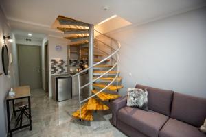a spiral staircase in a living room with a couch at Artemida Suites in Hanioti