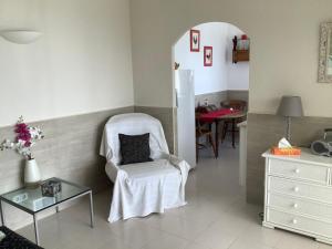 a living room with a white chair and a table at La Casita in Pau +20 photos