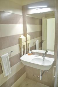 uma casa de banho com um lavatório e um espelho em Ouril Hotel Julia em Santa Maria