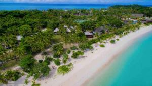 an aerial view of a beach with trees and the ocean at Mana Lagoon Backpackers in Mana Island