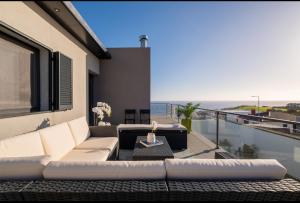 a living room with a couch and a view of the ocean at Casa Celeste - Deluxe Ocean View/Heated Pool in Ponta Garça