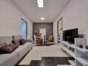 a living room with a couch and a flat screen tv at 21A01 Apartamento Cabañaquinta in Aller
