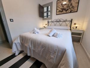 Un dormitorio con una gran cama blanca con toallas. en 21A01 Apartamento Cabañaquinta, en Aller