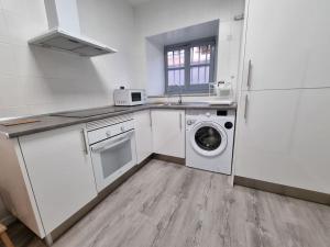 a kitchen with a washing machine and a refrigerator at 21A01 Apartamento Cabañaquinta in Aller