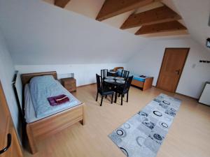 sypialnia z łóżkiem, stołem i krzesłami w obiekcie HostelHollabrunn w mieście Hollabrunn