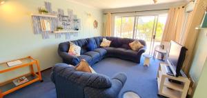ein Wohnzimmer mit einem blauen Sofa und einem Fernseher in der Unterkunft Club Cabana 13 - Sleeps 6 - Perfect Holiday Destination in Margate