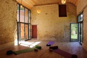 an empty room with yoga mats on the floor at LE DOMAINE DU PETIT TERTRE - SPA EN EXTERIEUR in Saint-Jean-dʼAssé