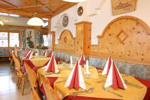 a dining room with tables with red and white napkins at Pension Sonneck in Neukirchen am Großvenediger