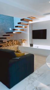 uma sala de estar com um sofá e uma televisão e escadas em Pé na Areia na Póvoa do Varzim