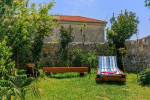 a garden with a bench and a chair in the grass at Santa Barbara in Drivenik