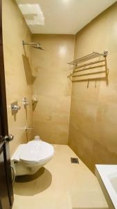 a bathroom with a toilet and a sink at Hotel Plaza Heights by RAK Rooms, Mangaluru in Mangalore